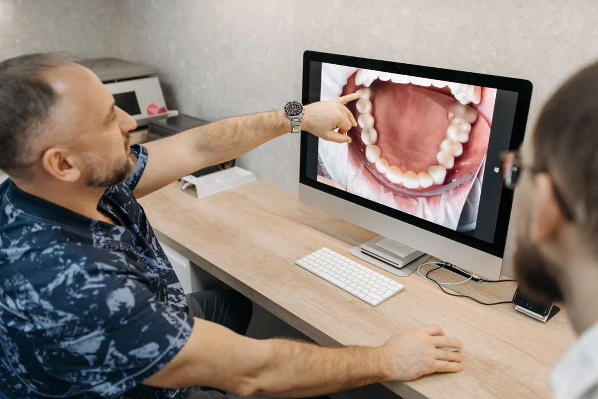 Dentist explaining progress with dental images on a monitor